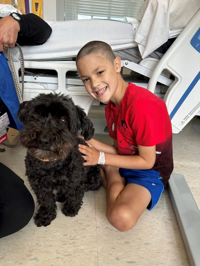 Jackson playing with one of the hospital's therapy dogs